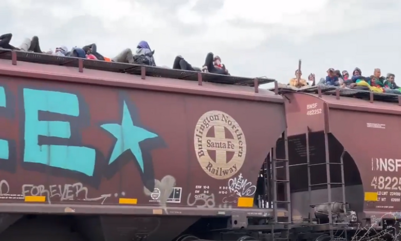 Hundreds of migrants travel on top of a train heading to the United States.