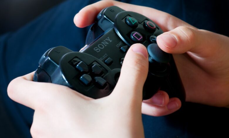 Bassano del Grappa, Italy - June 7, 2012: Hands of a young woman holding PlayStation wireless controller (gamepad)