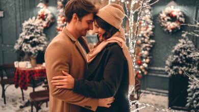 Couple embracing outside in front of winter light display