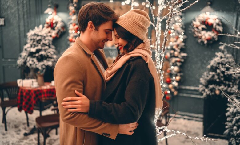 Couple embracing outside in front of winter light display