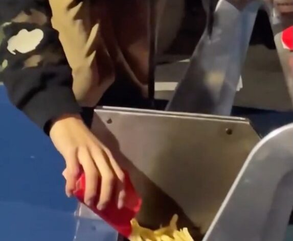 man putting french fries inside Lamborghini