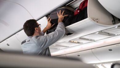 Person placing bag in overhead compartment