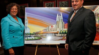 Assembly women Audry Pheffer & State Senetor Joseph P Addabbo stand in front of an isle with a painting of a casino, at a meeting held at Aqueduct racetrack.