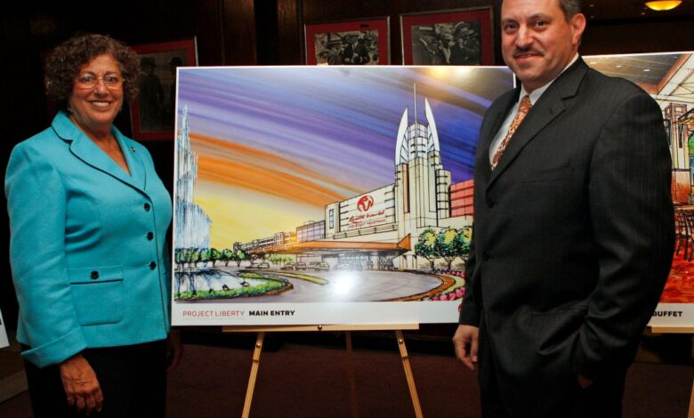 Assembly women Audry Pheffer & State Senetor Joseph P Addabbo stand in front of an isle with a painting of a casino, at a meeting held at Aqueduct racetrack.
