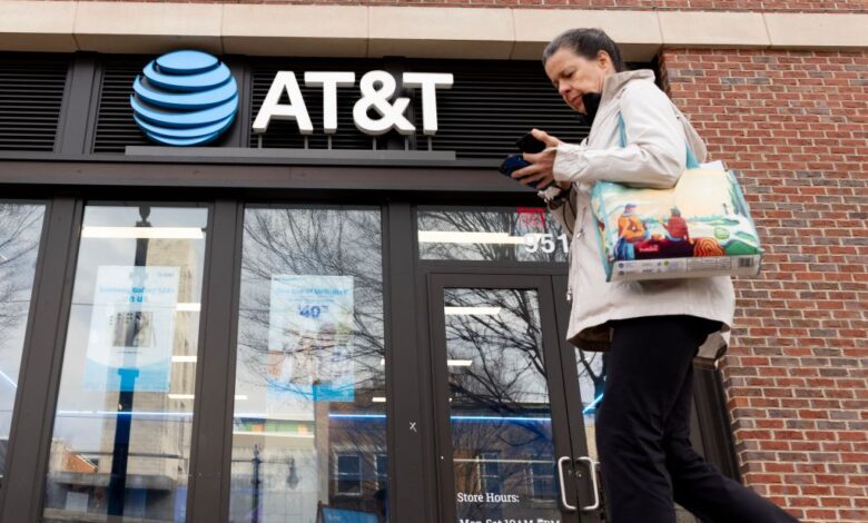 A pedestrian looking at a cell phone outside an AT&T retail store during an investigation into outages in Washington, USA - 22 Feb 2024.