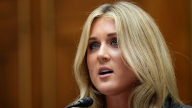 A blonde woman speaking into a microphone during a congressional hearing on Title IX and gender identity with Capitol Hill in background.