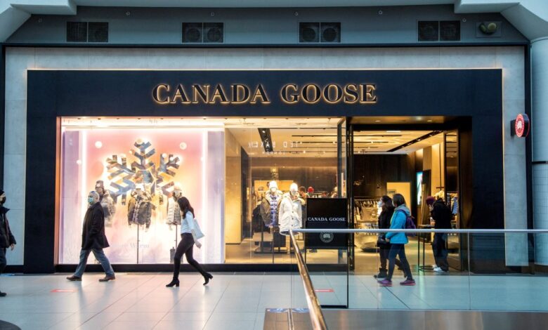 Canada Goose store in CF Toronto Eaton Centre shopping mall with people walking past, following announcement of corporate layoffs