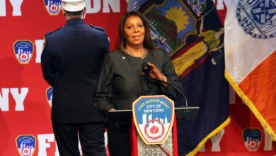 Attorney General Letitia James speaking at FDNY Promotion Ceremony with John Hodgens and Laura Kavanagh standing behind her.