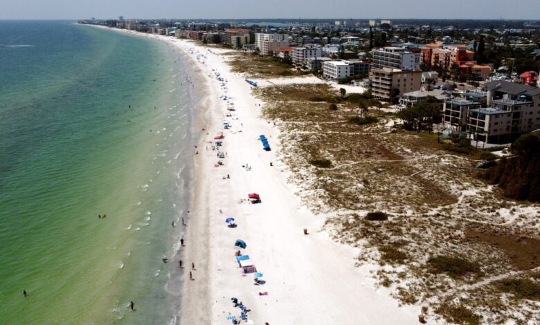 Aerial view of Florida's Gulf Coast beach with buildings, highlighting the surging real estate market