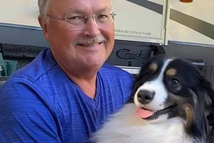 Gary Hoskins , seen here looking at the camera and smile while wearing a blue t shirt and holding a black and white dog, said in court papers he's been falsely accused of using "inappropriate" language during board meetings, and prevented from selling puppies.