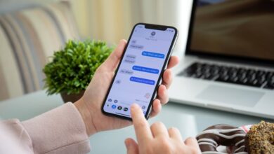 Woman hand holding iPhone X with social networking service iMessage on the screen.