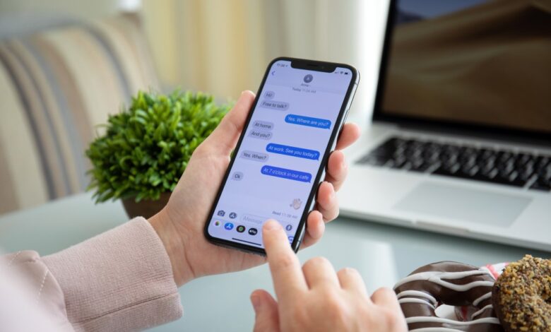 Woman hand holding iPhone X with social networking service iMessage on the screen.