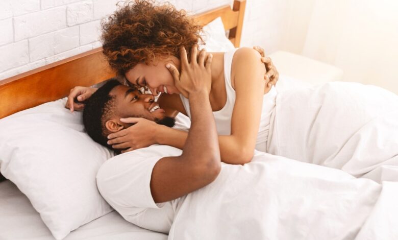 African couple of lovers relaxing and smiling in bed