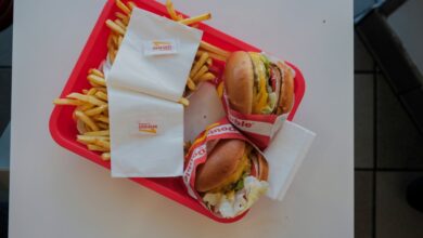 An In-N-Out burger, with a juicy beef patty, melted cheese, fresh lettuce, and tomato all stacked between two soft buns.