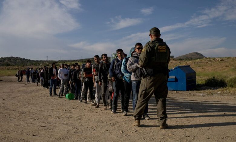 Male migrants from Jordan, China, Egypt and Colombia surrender to a border patrol agent after crossing into the U.S.