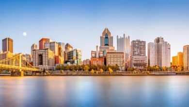 Long exposure view of Pittsburgh downtown skyline and Roberto Clemente bridge from North Shore Riverfront Park on a sunny afternoon