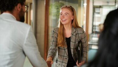 Young graduate woman shaking hands with a man during her first interview