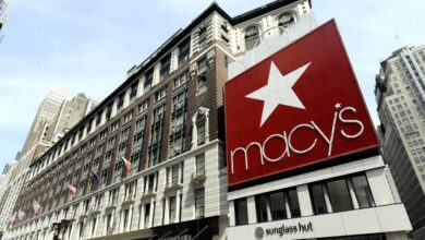 Exterior view of Macy's flagship store in New York with a large red sign and white star, reflecting a period of decline in company profits