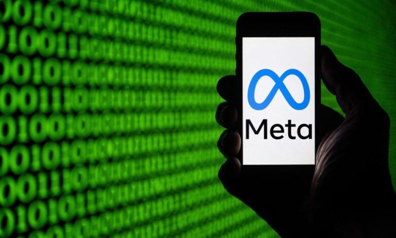 Meta logo on a phone in front of green and black coding background.