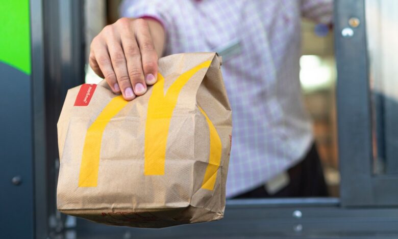 McDonald's worker in Sankt-Petersburg, Russia handing over a bag of fast food through the drive-thru window on July 21, 2019.