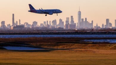 American Airlines Airbus A319 landing at JFK International Airport with Manhattan skyline in the background