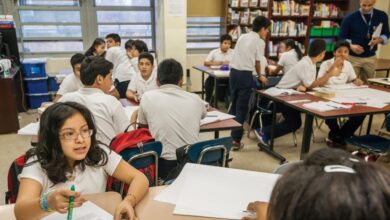 Middle school students actively participating in a classroom at M.S. 223 in the Bronx, New York.