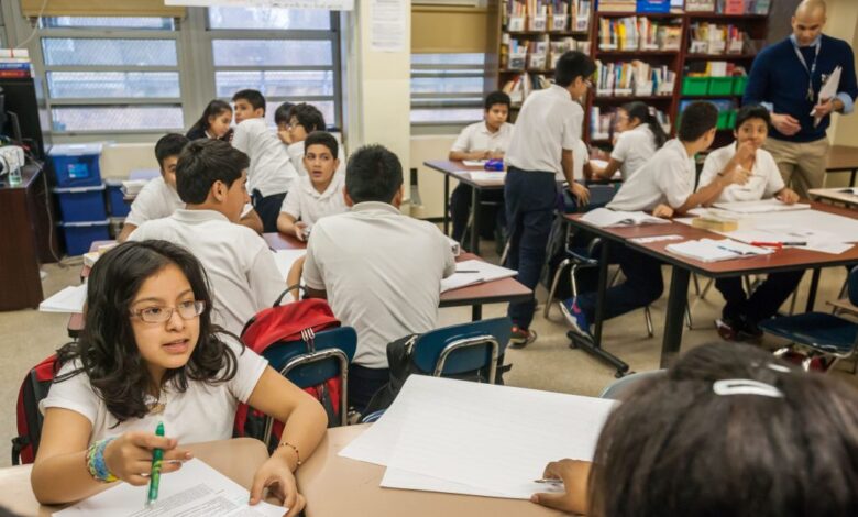 Middle school students actively participating in a classroom at M.S. 223 in the Bronx, New York.