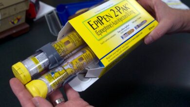 In this July 8, 2016, file photo, a pharmacist holds a package of EpiPens epinephrine auto-injector, a Mylan product, in Sacramento, California