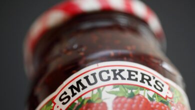 Close-up view of a jar of Smucker's preserves on a shelf.