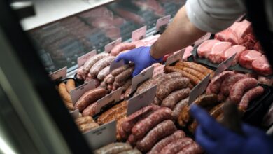 Andres Gonzalez placing pork sausages into a display case at Baron's Quality Meats in Castro Valley, California.