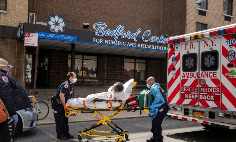 FDNY EMTs wearing protective equipment lifting a man from a nursing home into an ambulance during the COVID-19 outbreak in Brooklyn, New York