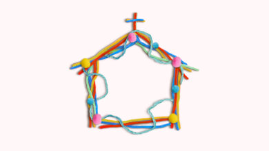 A church made of colorful pom-pom balls and pipe cleaners on a cream colored background