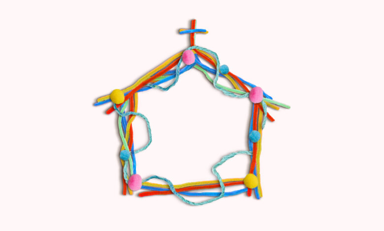 A church made of colorful pom-pom balls and pipe cleaners on a cream colored background