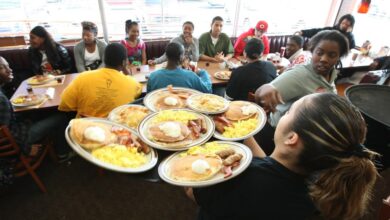 Denny's waitress, resembling Jaime Staples, delivering free Grand Slam breakfasts to customers during a special promotion