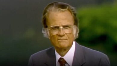 A screengrab of Billy Graham speaking in a classic video, wearing a suit with a green background.