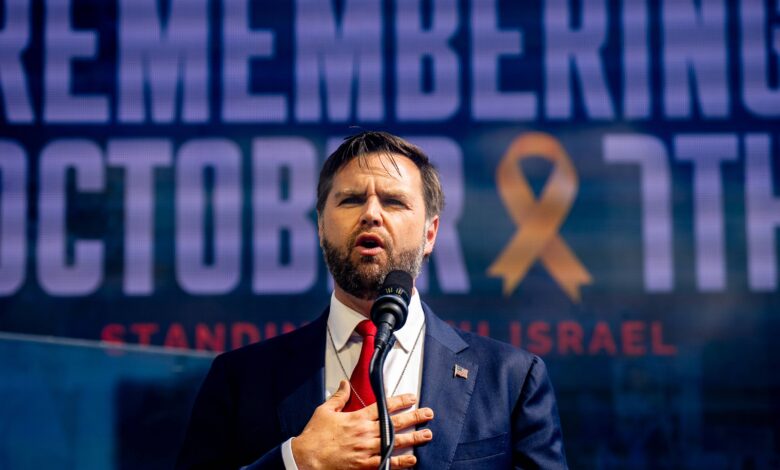 JD Vance places his hand on his chest speaking in front of a screen that reads "Remembering October 7"