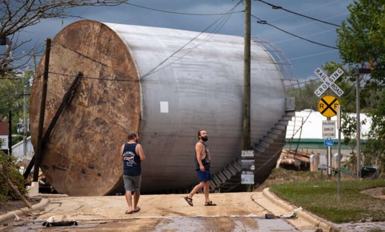 Men inspect damage in the aftermath of Hurricane Helene in Asheville, North Carolina.