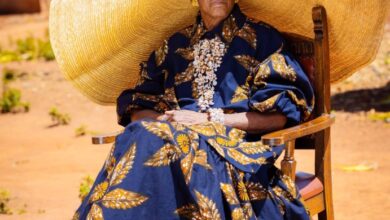 Margret Chola in a large hat and dress