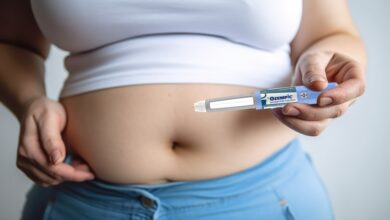 Woman holding an Ozempic semaglutide injection pen for diabetes and weight loss near her stomach