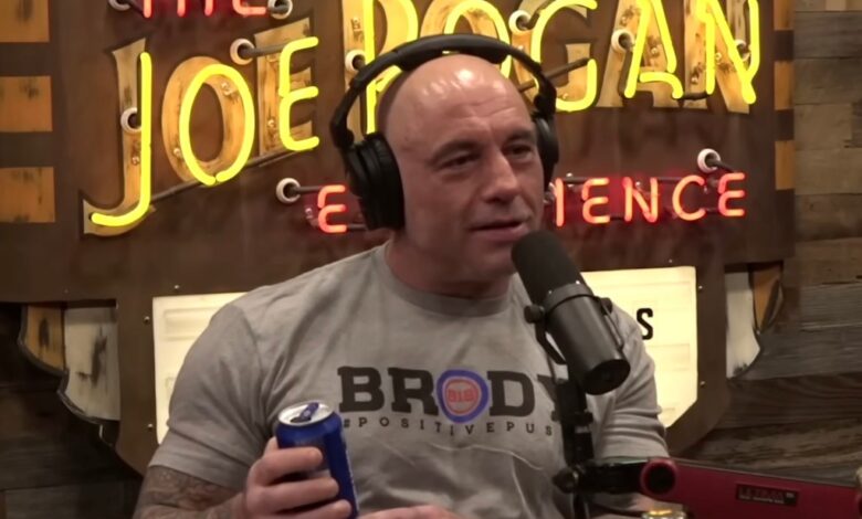 Joe Rogan wearing headphones, holding a can of Bud Light, in his podcast show