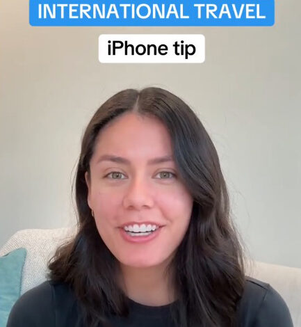 A woman explaining the new built-in currency converter feature on her iPhone, perfect for international travel