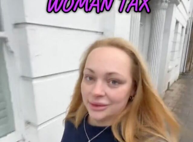 A woman taking a selfie, discussing the concept of 'woman tax' in her daily vlog