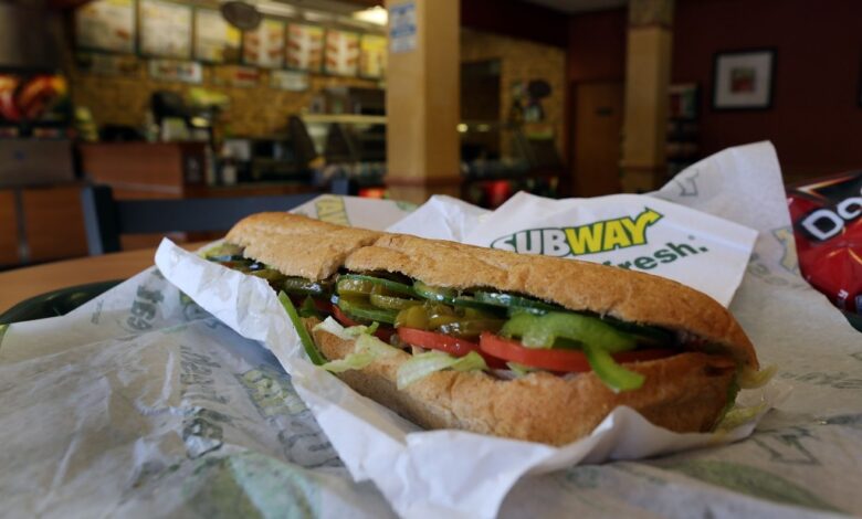 A Subway sandwich is seen in a restaurant as the company announced a settlement over a class-action lawsuit that alleged that Subway engaged in deceptive marketing for its 6-inch and 12-inch sandwiches and served customers less food than they were paying for on October 21, 2015 in Miami, Florida.