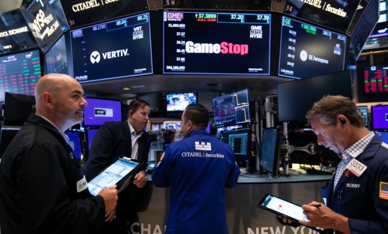Traders work underneath GameStop sign on the New York Stock Exchange.