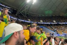 TikTok user @em.robertsonn3 and others observing a large group of female fans taking a seat on the stair walkway during a women's football game