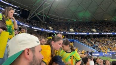 TikTok user @em.robertsonn3 and others observing a large group of female fans taking a seat on the stair walkway during a women's football game
