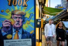 Cryptocurrency exchange office in Hong Kong with a screen featuring President Trump holding cryptocurrency coins.