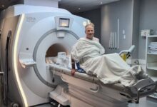 Scolyer poses on and MRI machine