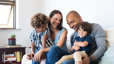 Happy multiethnic family laughing on a couch.