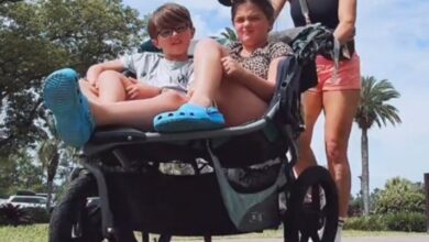 Woman pushing two children in a stroller at Disneyland.